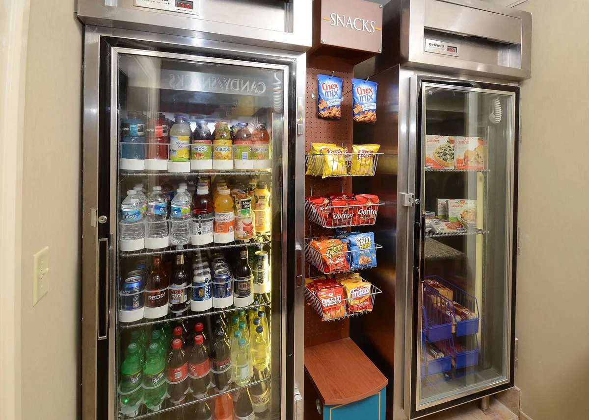 A beverage cooler and snack shelves provide quick access to refreshments, while guests socialize in a relaxed, casual atmosphere. The space is inviting and ideal for sharing food and drinks with friends or family.